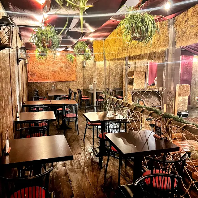 Sala del Tortuga con tavoli, luci calde e vegetazione scenografica