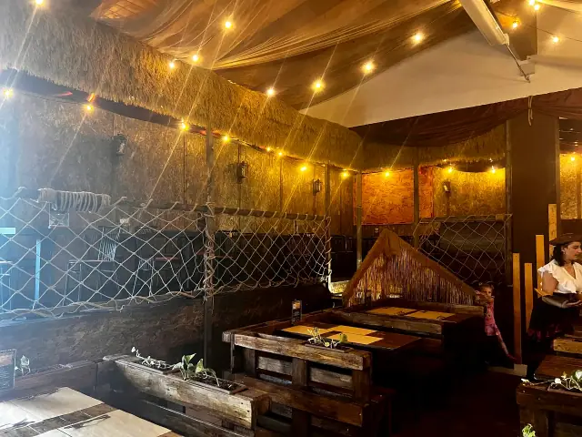 Tavoli del Tortuga sotto luci calde e scenografie piratesche